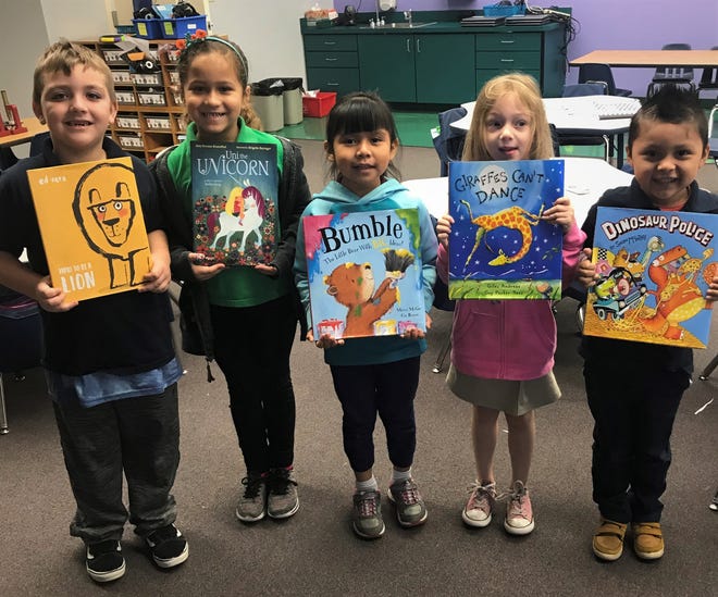 Students proudly display books from Book Buddies, part of a social action initiative with volunteers from Temple Beth Sholom and Sandhill Preserve. [SUBMITTED PHOTO]