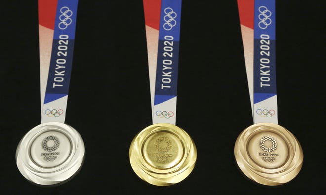 Tokyo 2020 Olympic medals are unveiled during a One Year to Go Olympic Ceremony event on Wednesday in Tokyo. The reveal marked exactly a year until the games open. [Koji Sasahara/The Associated Press]