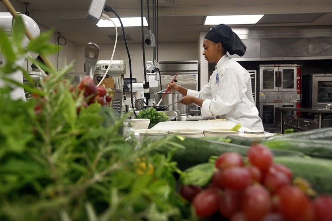 A student from the Institute of Culinary Arts at Eastside High School prepares a dish that is required to include a fresh fruit or vegetable as part of a cooking competition sponsored by the Florida Department of Agriculture and Consumer Services. [Gainesville Sun, File]