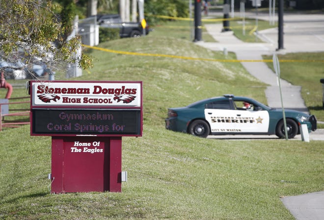 Law enforcement officers block off the entrance to Marjory Stoneman Douglas High School in Parkland following a mass shooting there on Feb. 14, 2018. [AP FILE PHOTO BY WILFREDO LEE]