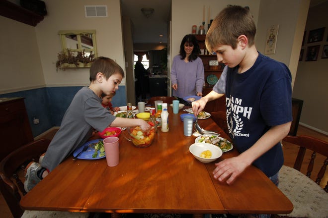 A family gathers around the dinner table at their home. [AP Photo/ Joseph Kaczmarek/ File]