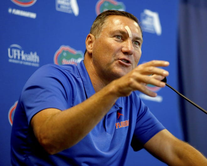Florida football coach Dan Mullen talks with members of the media Thursday during the annual Florida Football Media Day at Ben Hill Griffin Stadium. Mullen was sporting a bandage over his right eye after suffering a bump earlier, he said. [Brad McClenny/Staff photographer]