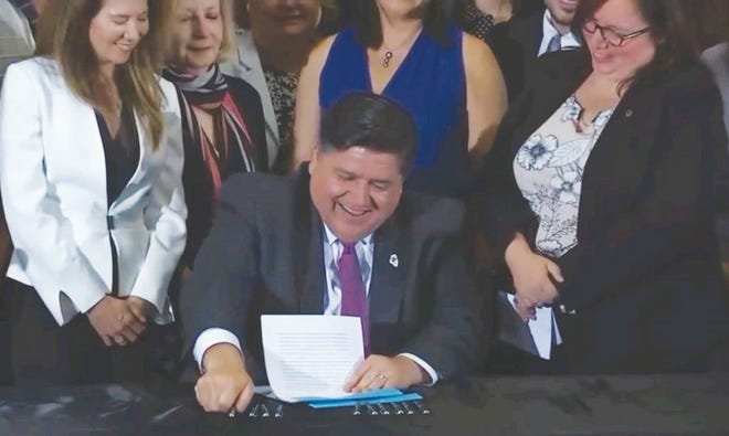 Gov. J.B. Pritzker signs into law two bills aimed at protecting children of unauthorized immigrants during a ceremony Tuesday at the Mexican Art Museum in Chicago.