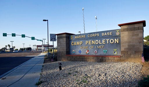 FILE - This Nov. 13, 2013 file photo shows the main gate of Camp Pendleton Marine Base at Camp Pendleton, Calif. A human smuggling investigation by the military led to the arrest of 16 Marines Thursday, July 25, 2019 while carrying out a battalion formation at California's Camp Pendleton, a base about an hour's drive from the U.S.-Mexico border. (AP Photo/Lenny Ignelzi, File)