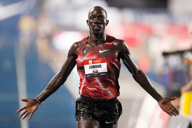 Lopez Lomong celebrates his win in the men's 10,000-meter run at the U.S. Outdoor Track & Field Championships on Thursday in Des Moines, Iowa. [AP Photo/Charlie Neibergall]