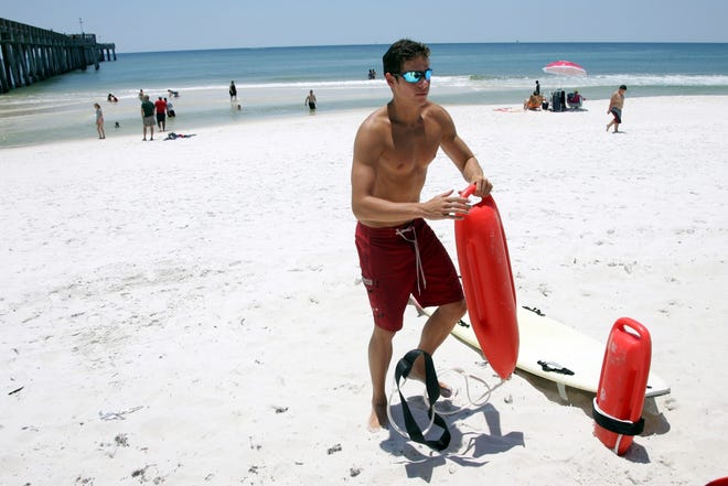 Bryant Clayton, a beach lifeguard puts down a life saving device while on duty below the Russell Fields Pier in Panama City Beach Wednesday.