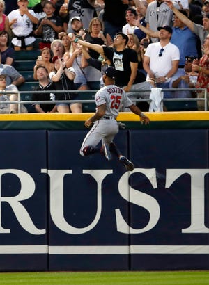 Minnesota Twins center fielder Byron Buxton climbs the wall trying to catch the home run ball hit by Chicago White Sox center fielder Adam Engel during third inning Friday, July 26, 2019, in Chicago. [JEFF HAYNES/THE ASSOCIATED PRESS]