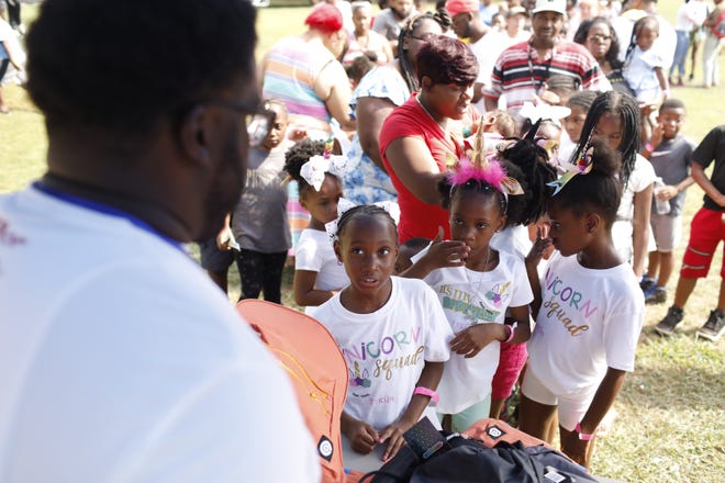 Event organizer and musician Ben Edwards hands out backpacks to children at the East Athens Community Center on Saturday, July 27, 2019. [Photo/Joshua L. Jones, Athens Banner-Herald]