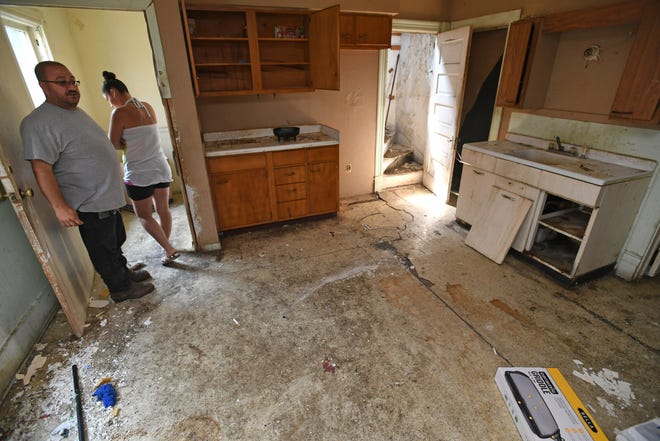 Roberto Ramos, 51, left, and his wife Ashley Ramos, 25, show off the kitchen area in an upstairs apartment in a duplex they own at 619 E. 22nd St. The couple is rehabilitating several properties in the 600 block of East 22nd Street and think the city of Erie's Community Reinvestment Fund could help homeowners like them who are trying to improve the housing stock in Erie's neighborhoods. [CHRISTOPHER MILLETTE/ERIE TIMES-NEWS]