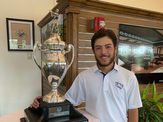 Jordan Batchelor displays the Jacksonville Amateur championship trophy after winning the title on Saturday at the Sawgrass Country Club. [Garry Smits/The Times-Union]