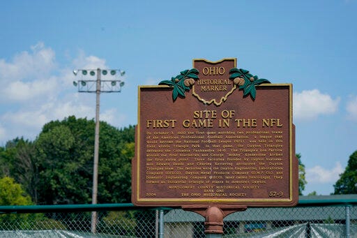 A plaque commemorating the site of the first NFL football game stands in Triangle Park, Saturday, July 27, 2019, in Dayton, Ohio. (AP Photo/Bryan Woolston)