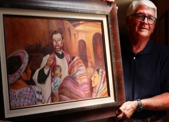 Artist Chuck Schroeder, former president and executive director of the Cowboy Hall & Western Heritage Museum, shows his oil painting of Blessed Stanley Rother on Friday at the Catholic Pastoral Center. The painting will be presented to Holy Trinity Catholic Church on Saturday in Okarche. [Doug Hoke/The Oklahoman]
