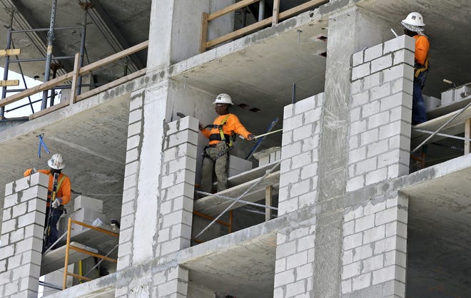In this file photo from 2017, construction workers work on an apartment high rise in Miami. Estimates put the population of Florida at 22 million in 2022. [AP Photo/Alan Diaz]