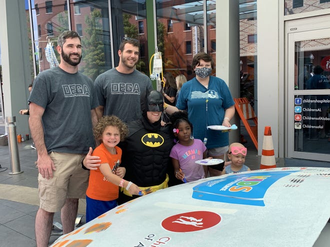 With the help of some of the Talladega Superspeedway staff and Batman, these kids from Children’s of Alabama in Birmingham painted the track’s Kids VIP Experience stock car on Friday morning, July 26, 2019. [Submitted photo]