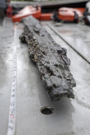 Archaeologists examine a loose piece of the wrecked Gulf schooner Clotilda, in delta waters north of Mobile Bay in May 2019. [Daniel Fiore/SEARCH, Inc. via AP]