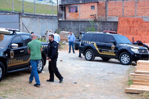 Police inspect the vehicles that were left by suspects involved in heist carried out at Sao Paulo's Guarulhos international airport, in the Jardim Pantanal neighborhood of Sao Paulo, Brazil, Thursday, July 25, 2019. Authorities at Sao Paulo's Guarulhos international airport say eight armed men raided a terminal and escaped with some 750 kilos (750,000 grams) of precious metals. The airport operator said that the thieves bypassed security systems by using two cars that looked like police vehicles. (Paulo Lopes/Futura Press via AP)