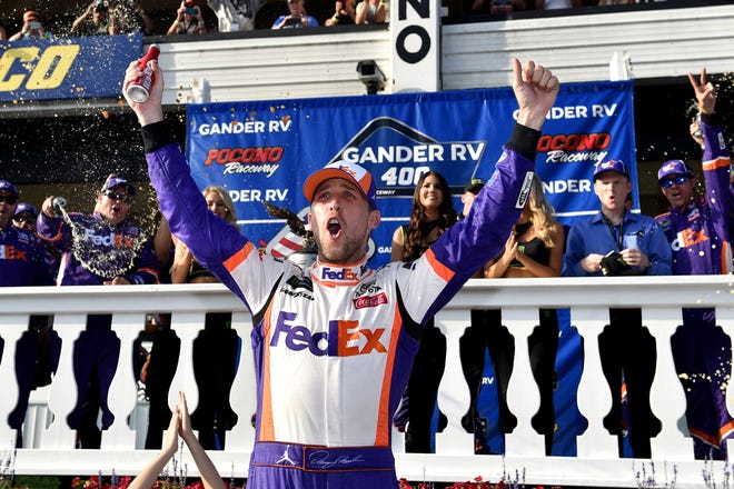 Denny Hamlin celebrates in victory lane after winning a NASCAR Cup Series race Sunday in Long Pond, Pa. [DERIK HAMILTON/THE ASSOCIATED PRESS]
