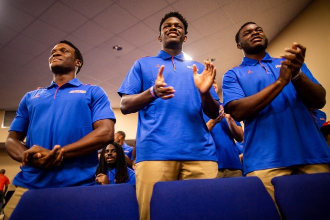 University of Florida football players clap during a church service on Sunday at Showers of Blessings Harvest Center in Gainesville. [AARON RITTER/CORRESPONDENT]