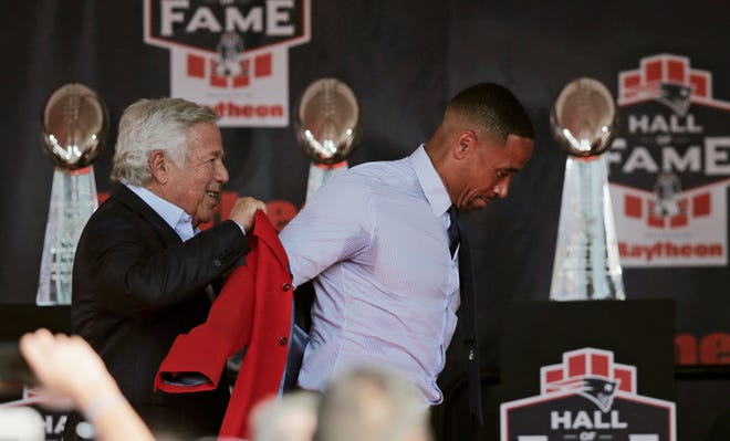 New England Patriots owner Robert Kraft, left, raises the team's Hall of Fame jacket onto the shoulders of former safety Rodney Harrison during an induction ceremony in the New England Patriots Hall of Fame in Foxborough, Mass., Monday, July 29, 2019. (AP Photo/Charles Krupa)