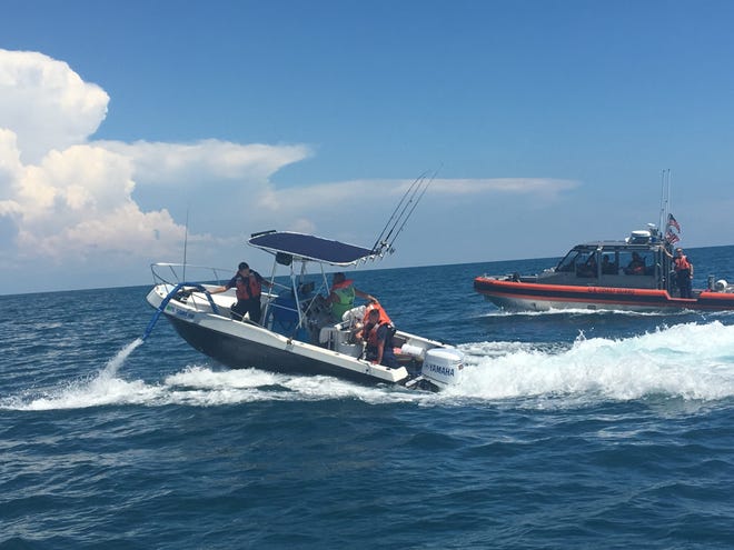 The crew members of Coast Guard Station Cortez dewater a pleasure craft vessel offshore of Bean Point on July 28, 2019. The pleasure craft had been taking on water approximately 12 miles offshore before requesting assistance. [PHOTO BY LONGBOAT KEY POLICE DEPARTMENT]