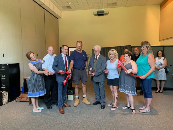 Tullytown Mayor David Cutchineal cuts the ribbon on Santarsiero's new office. The new location will provide more accessible constituent services to many District 10 Lower Bucks residents. [RILEY ROGERSON / STAFF]