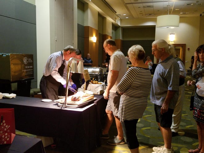 Guests line up at the Webb Custom Kitchen Booth at the 2017 Sip & Savor Gaston event. [GAZETTE FILE PHOTO]