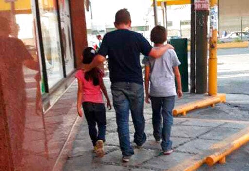 This July 24, 2019 photo courtesy of Guatemalan migrant Lucia shows her husband Rene with their 7-year-old daughter and 11-year-old son, as they walk in search of a place to sleep in Monterrey, Mexico. Rene said they were given a Sept. 20 court date in the U.S. for their asylum request, and promised Mexico would provide housing, work and schooling, but in Mexico they were bused to Monterrey without explanation or support. (Lucia via AP)