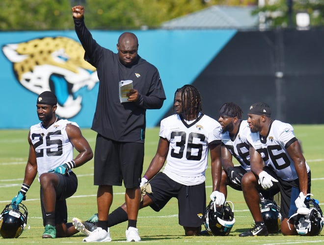 Drametrice Smith signals from the sidelines as D.J. Hayden, Ronnie Harrison, C.J. Reavis and Jerrod Wilson watch the action from the sidelines during Thursday morning's training camp session. [Bob Self/Florida Times-Union]