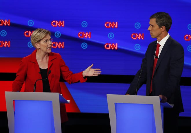 Sen. Elizabeth Warren, D-Mass., gestures to former Texas Rep. Beto O'Rourke during the first of two Democratic presidential primary debates in the Fox Theatre in Detroit. The tug-of-war over the future of the party early in the 2020 season pits voters' hearts against their heads as they balance their desperate desire to find an electable candidate to take on President Donald Trump with their strong preference for dramatic change. [THE ASSOCIATED PRESS]