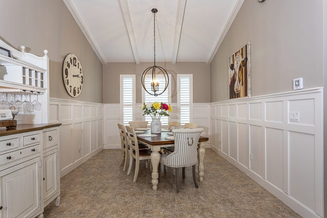 The dining room has been planned out with details that "wow" – from the decorative paneling on the walls and tile flooring to the designer lighting. [Coldwell Banker Premier Properties]
