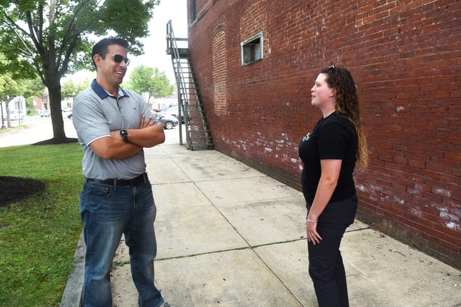 New owner of the Bennett building, Justin Gargiulo, as well as Make Rochester Great founder Jess Clay show the area where Clay will paint her mural (honeycomb and lilacs) on the historic building's exterior. Gargiulo is planning a $1 million mixed-use renovation. [Deb Cram/Fosters.com]