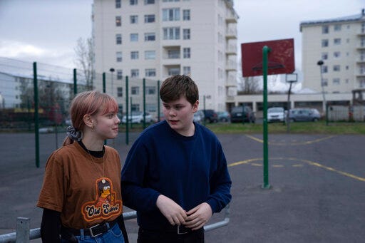 This photo taken Monday, May 13, 2019, shows Karen Guttensen and Ingvar Ingolfsson, right, both 14-years old, outside the Tjornin youth center in Reykjavik, Iceland, on a bright summer night. The island nation in the North Atlantic has dried up a teenage culture of drinking and smoking by focusing on local participation in music and sports options for students, with such success that Icelandic teens now have one of the lowest rates of substance abuse in Europe. (AP Photo/Egill Bjarnason)