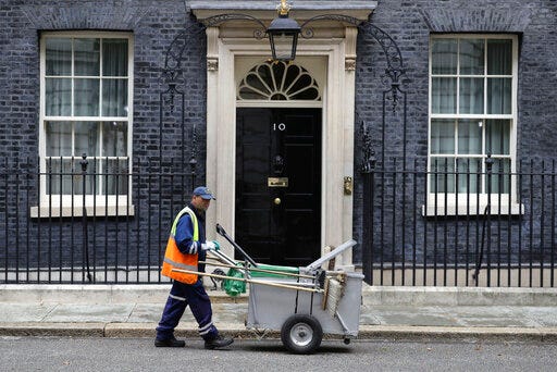A street cleaner outside 10 Downing Street in London, Wednesday July 31, 2019. British Prime Minister Boris Johnson is away from Downing street on a national tour to visit Scotland, Wales and Northern Ireland, seeking to reassure voters and regional politicians that Britain's Brexit split from Europe won't hurt the economy in the longterm or rip the U.K. apart. (Aaron Chown/PA via AP)