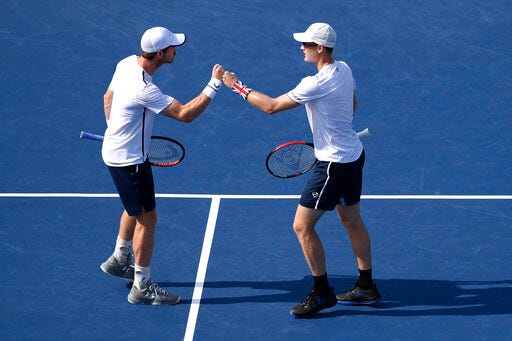 Andy Murray, left, and Jamie Murray, right, both of Britain, bump fists during a doubles match in the Citi Open tennis tournament against Nicolas Mahut and Edouard Roger-Vasselin, both of France, Wednesday, July 31, 2019, in Washington. (AP Photo/Nick Wass)