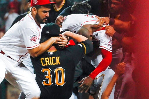 Pittsburgh Pirates' Kyle Crick (30) and Cincinnati Reds' Eugenio Suarez, left, and Amir Garrett, center right, are part of a brawl during the ninth inning of a baseball game Tuesday, July 30, 2019, in Cincinnati. (AP Photo/John Minchillo)