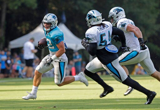 Carolina Panthers' Christian McCaffrey (22) runs as Shaq Green-Thompson (54) and Luke Kuechly pursue during practice at the NFL football team's training camp in Spartanburg, S.C., Monday, July 29, 2019. (AP Photo/Chuck Burton)