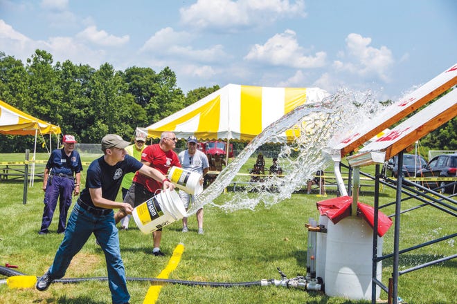 Photos by Warren Westura/New Jersey Herald — 
Area firefighters demonstrate the use of a bucket brigade to fight fires during a contest at the third annual Blairstown firefighter skills competition and flea market/vendor fair held this past weekend at Sycamore Park in Blairstown.