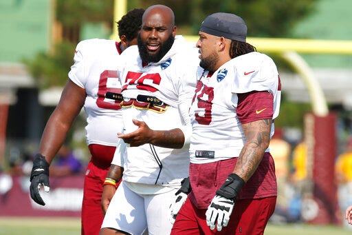 New offensive lineman for the Washington Redskins, Donald Penn (79) talks with offensive tackle Morgan Moses (76) during NFL football training camp in Richmond, Va., Wednesday, July 31, 2019. Penn was signed Wednesday. (AP Photo/Steve Helber)