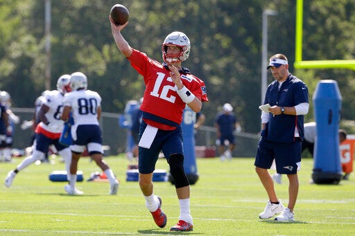 New England Patriots quarterback Tom Brady (12) passes the ball as offensive coordinator Josh McDaniels, right, looks on during an NFL football training camp practice, Thursday, July 25, 2019, in Foxborough, Mass. (AP Photo/Steven Senne)