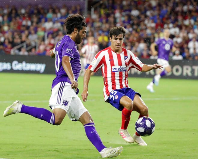Los Angeles FC forward Carlos Vela, left, tries to get position for a shot against Atletico Madrid defender Manu Sanchez (35) during the first half of the MLS All-Star soccer match Wednesday, July 31, 2019, in Orlando, Fla. (AP Photo/John Raoux)
