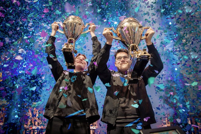 In this Saturday, July 27, 2019 photo, provided by Epic Games, Emil "Nyhrox" Bergquist Pedersen, of Norway, left, and David "Aqua" Wang, of Austria, hold up their trophies after winning the Fortnite World Cup duo championship in New York. (Epic Games via AP)