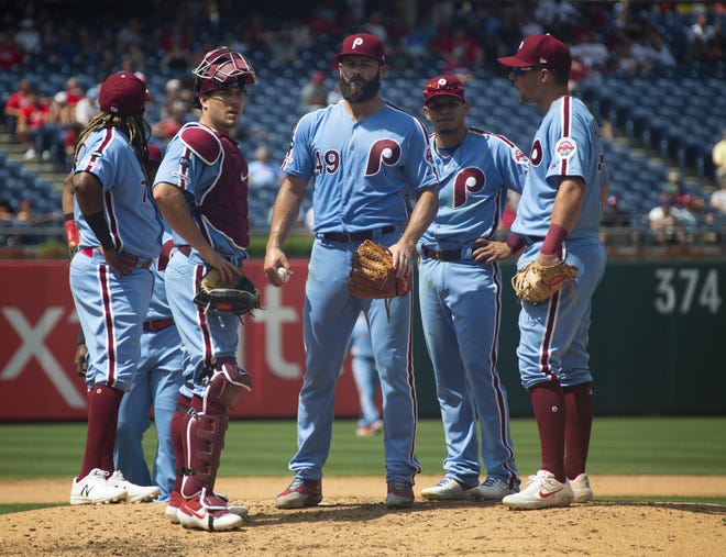 Philadelphia Phillies' Jake Arrieta, center, looks on with his teammates as he waits to be pulled from the game during the fifth inning of a game against the San Francisco Giants Thursday in Philadelphia. [AP PHOTO/CHRIS SZAGOLA]