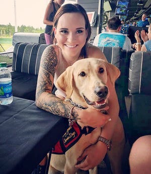 Katie Cowham enjoys some time at Top Golf with Indy, a service dog, who alerts her to dangerous dips and spikes in her blood sugar. [Diabetes Alert Dog for Katie/Facebook]