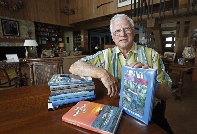 Author Sam Cromartie poses with some of his books at his Ormond Beach home. Cromartie, a former surgeon, specializes in historical fiction and thrillers. "I wouldn't call it work," Cromartie said. "I've always liked to write." [News-Journal/Nigel Cook]