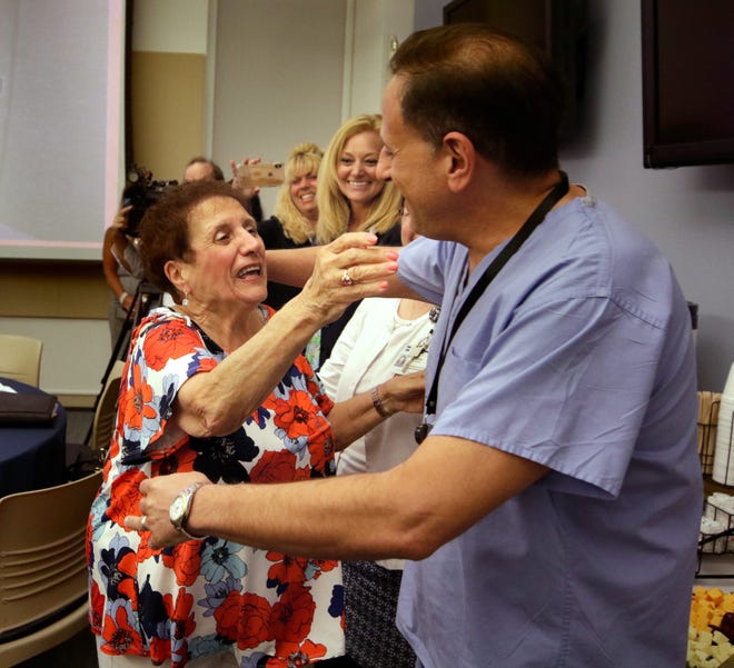 Providence, RI, July 31, 2019 - Giovanna "Jenny" Todisco readies to give OB/GYN doctor, David Carcieri, a big hug as she makes her way around the room hugging and kissing friends and family that met to give her a happy send off from her many years at Woman and Infants. Wednesday afternoon. Giovanna "Jenny" Todisco of Johnston, Rhode Island, a licensed practical nurse in the Emergency Department, is retiring from nursing at Women & Infants Hospital after over 59 years of service in the health care industry. Jenny is the longest tenured nurse at Care New England. Ms. Todisco graduated from Our Lady of Fatima Hospital School for LPN in 1960, and started working as an LPN at Women & Infants Hospital in March of that same year. [The Providence Journal / Kris Craig]