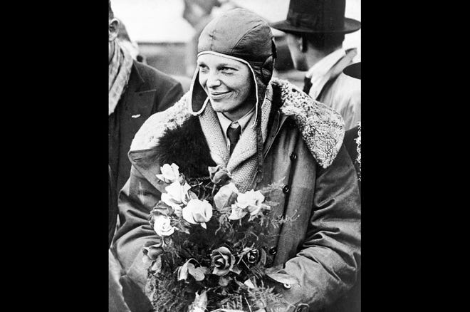 Amelia Earhart poses with flowers as she arrives in Southampton, England, in June 1928, after her transatlantic flight on the Friendship. [ASSOCIATED PRESS FILE PHOTO]