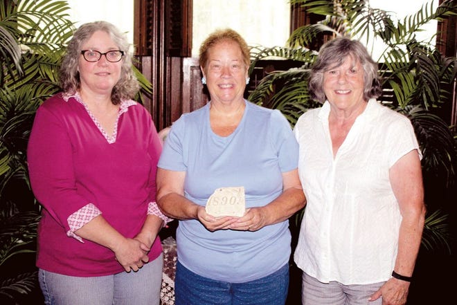 Amos Sturgis DAR registrar Laura Telsworth, regent Joetta Cherry and treasurer Liz Campbell with the piece of grave that started their work with the cemetery.