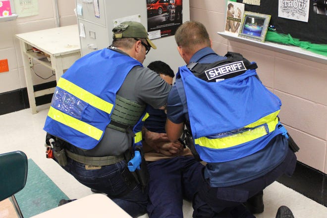 Training participants from the Lafourche Parish Sheriff's Office and the Port Fourchon Harbor Police render aid to a mock gunshot victim following a response to an active shooter incident. [Submitted]