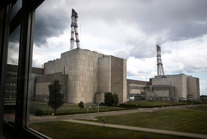 In this photo taken on July 16, workers walk past a part of the Ignalina nuclear power plant in Visaginas some 100 miles northeast of the capital Vilnius, Lithuania. The HBO TV series “Chernobyl” featuring Soviet era nuclear nightmares is drawing tourists to the atomic filming locations in Lithuania. [MINDAUGAS KULBIS/ASSOCIATED PRESS]