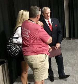 Kansas City Chiefs broadcaster Mitch Holthus, right, visits with coaches before speaking to the Kansas State High School Activities Association's 87th annual coaching school on Monday at the Maner Conference Center. [Rick Peterson/The Capital-Journal]